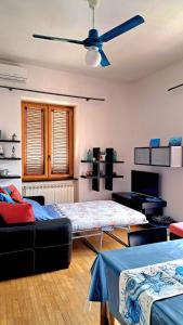 a living room with two beds and a ceiling fan at Coral & Turquoise in Pozzuoli