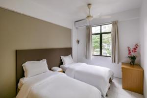 ein Hotelzimmer mit zwei Betten und einem Fenster in der Unterkunft 3-Bedroom Stay at Macalister Road & Georgetown, Noble Villa Penang in George Town + 55 Fotos