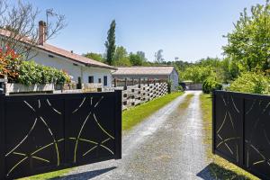 a driveway with two gates in front of a house at Appartement 6 Personnes Soustons in Soustons