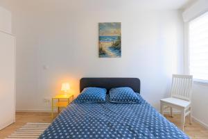 a bedroom with a bed with a blue bedspread at Appartement 6 Personnes Soustons in Soustons