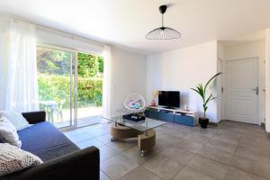 a living room with a couch and a tv at Appartement 6 Personnes Soustons in Soustons