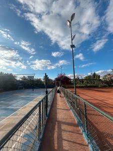 a person is standing on a tennis court at MSC Sport Campus in Marrakesh