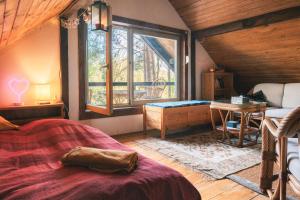 a bedroom with a bed and a large window at Babi Domek - Leśny dom z balią in Kruczy Borek +29 photos