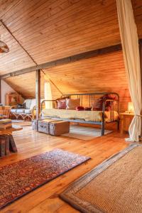 a bedroom with a bed on a wooden ceiling at Babi Domek - Leśny dom z balią in Kruczy Borek