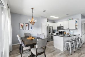 a kitchen and dining room with a table and chairs at Romar Lakes 103B in Orange Beach +22 photos