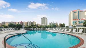a large swimming pool with chairs and buildings in the background at Romar Lakes 103B in Orange Beach