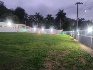 モンテイロ・ロバートにあるCasa de Campo e Eventos Villa Chico Diasの塀の上に灯る夜間のサッカー場 +3枚の写真