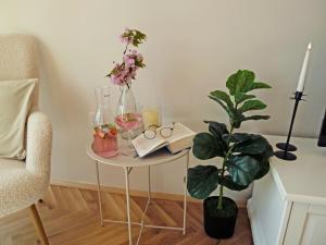 a table with glasses and a plant and a candle at AURA BEACH apartment in Burgas