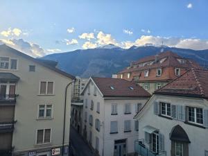 a group of buildings with mountains in the background at Zimmer perla in Chur