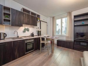 a kitchen with wooden cabinets and a sink and a table at Italstay - Bollo Studio flat - 5 min to Duomo in Milan +8 photos