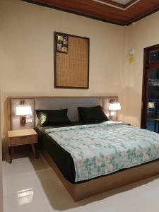 图克图克Bloom Home Stay的一间卧室，配有一张床、两个床头柜和两盏灯