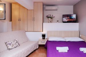 a living room with a couch and a purple blanket at Apartments Zdenka in Vinišće