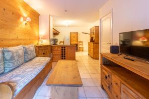 a living room with a couch and a flat screen tv at Alba Lodge, 2 min de la télécabine, vue montagnes in Brides-les-Bains