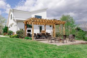 a wooden pergola with a table and chairs on a patio at Reynolds View in Asheville