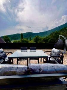 a table and chairs on a deck with a view at Qafqaz Mountain Terrace İndoor Hot Pool in Gabala