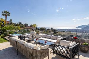 un patio con sofás y una mesa en REF 2165- Mandelieu La Napoule- Sea view Villa for rent, en Mandelieu-la-Napoule