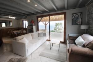 a living room with a couch and a table at Le petit belvédère chalet avec piscine & vue lac in Ontex
