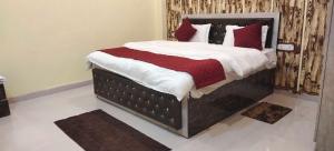 una camera da letto con un letto con cuscini rossi e bianchi di Hotel O Suryavanshi Palace a Ayodhya