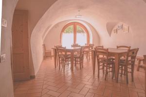 a dining room with tables and chairs and a window at Agritur Ca' de Mel in Fiavè