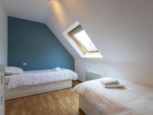 a attic bedroom with two beds and a skylight at Maison De Charlie 4 personnes in Trégastel