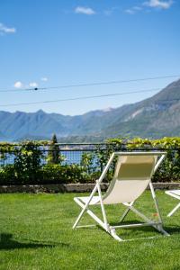 a lawn chair sitting on the grass with a view at Casa di Lou - Panoramic villa in Perledo in Perledo