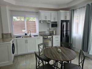 una cucina con un tavolo di legno e un tavolo e sedie di Agape Suites-Room 2-Ground Floor a Soufriere Altre 6 foto