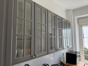 a white cabinet with glass doors in a room at L'authentique - Hyper centre et Gare in Saint-Brieuc