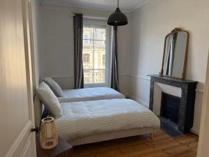 a bedroom with a bed with a fireplace and a mirror at L'authentique - Hyper centre et Gare in Saint-Brieuc