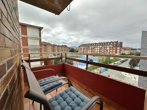 a balcony with two chairs and a view of a city at La Espina, en Somo - 30024 in Somo