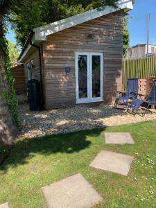 a shed with two chairs in a yard at Y Caban-The Cabin-2 Guests-Private Parking-Fast WIFI in Llanelli