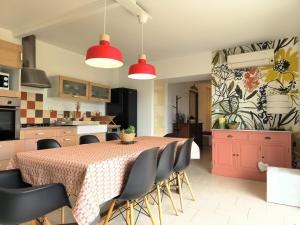 eine Küche und ein Esszimmer mit Tisch und Stühlen in der Unterkunft LES BOHEMIELLES 4**** Cottage MARTIN in Cartelègue
