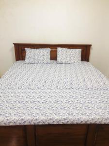 1 cama con marco de madera y 2 almohadas en Sasi Blossom, en Nikawatawana 28 fotos más