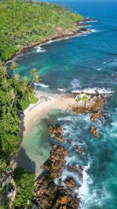 an aerial view of a beach and the ocean at Parrot Tree House in Mirissa