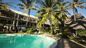 a pool in front of a hotel with palm trees at Kisiwa Apartments Watamu - At Ascot Resort - in Watamu