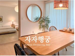 a dining room with a table and a mirror at JAJA Haenggung, SuwonㅣNext to Hwaseong FortressㅣCozy Korean VibeㅣComfortable & Well-keptㅣUp to 8 guestsㅣFree ParkingㅣLoved by many guests in Suwon +60 photos