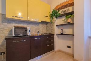 a kitchen with yellow cabinets and a microwave at Casa Di Dea in Porto Azzurro