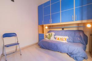 a small bedroom with a blue bed and a chair at Casa Di Dea in Porto Azzurro