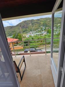 a balcony with a chair and a view of a mountain at Agape Suites-Room 3- 1st Floor in Soufrière