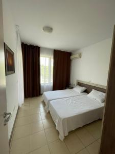 チェルノモレツにある1BD Flat on the Beach with Parking by Flat Mаnagerのベッド2台と窓のある寝室