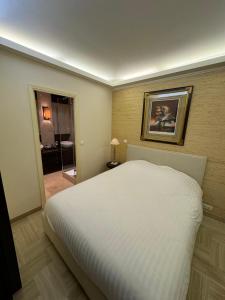 a bedroom with a white bed and a bathroom at GRAY D ALBION Residence in Cannes