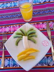a plate with fruit and a glass of orange juice at Titicaca UTJAWI LODGE in Puno +51 photos