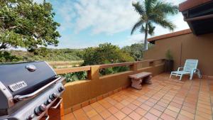 サウスブルームにあるSan Lameer Lagoon Blissのグリルと椅子のある屋外パティオ