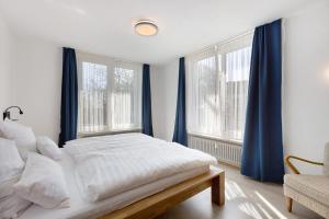 a bedroom with blue curtains and a bed and a window at Hegaudomizil in Engen