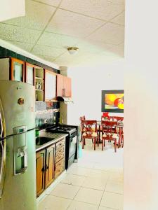 a kitchen with a refrigerator and a dining room at Golden House festivalera II para 10 personas in Valledupar