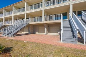 an apartment building with stairs and a parking lot at Beach Baby by Gulf Coast Getaways in Navarre