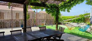 a wooden table and chairs on a patio at maison de village in Laplume