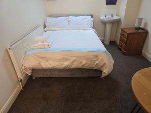 a small bedroom with a bed and a sink at Realwood Homes- Birrell Road in Nottingham