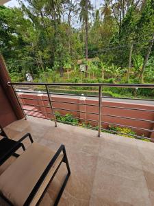 a balcony with a table and chairs and a fence at Agape Suites-Room 4- 1st Floor in Soufrière