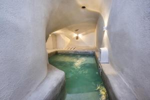 a small pool of green water in a tunnel at Gilbert's Cave with cave jacuzzi in Megalochori