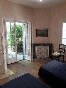 una camera da letto con un letto, un camino e porte scorrevoli di Arcachonaise à 50 m de la plage, Arcachon Centre ad Arcachon